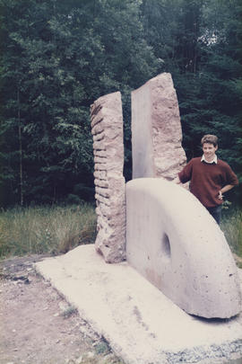 Photograph of artist Tim Lees standing next to his sculpture The Heart of Stone